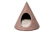 Ein Tipi für kleine Hunde aus hellbraunem Wollfilz mit einem Liegekissen aus hell gestreifter Baumwolle.